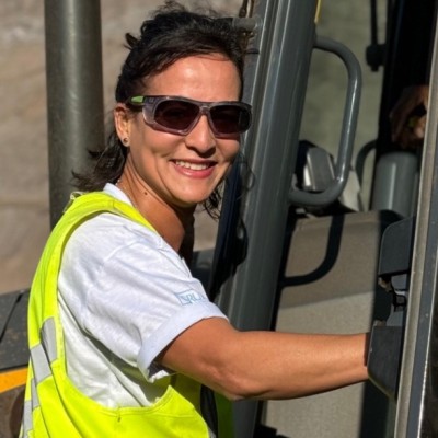 Foto da instrutora Gilvana, que é uma mulher parda de cabelos escuros usando óculos de segurança em um caminhão